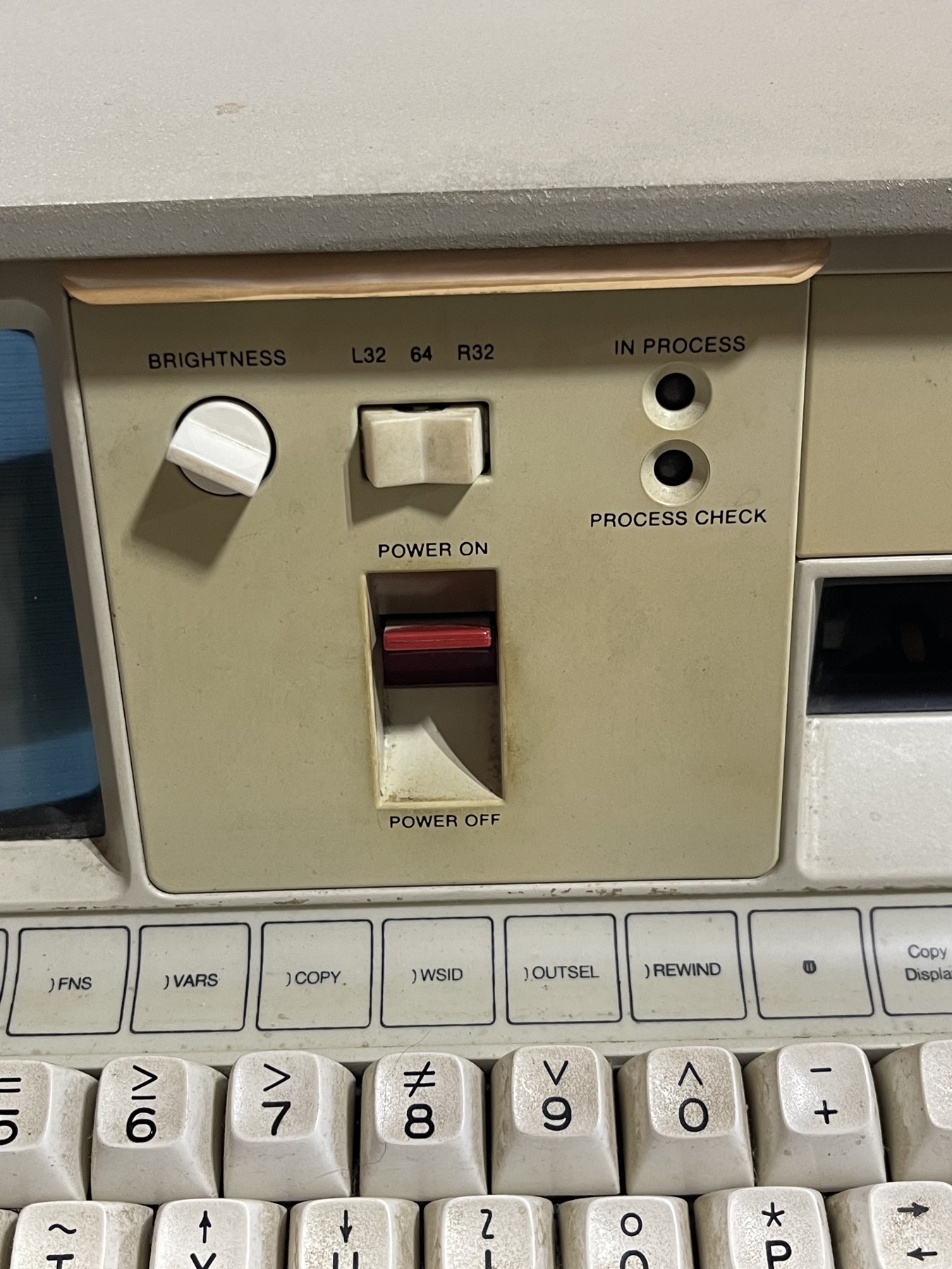 Close-up of the IBM 5100 control panel: brightness dial, L32/64/R32 memory switch, red power rocker and APL function keys